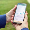 Two hands hold a phone displaying an application.