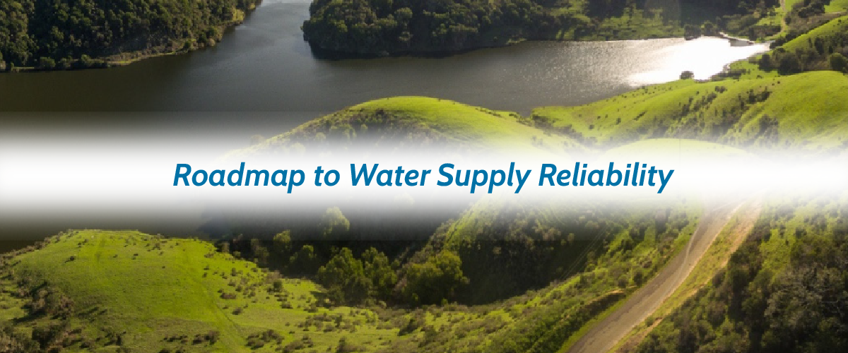Image shows a lake surrounded by verdant hills, and the following text superimposed in blue with a white background: "Roadmap to Water Supply Reliability."