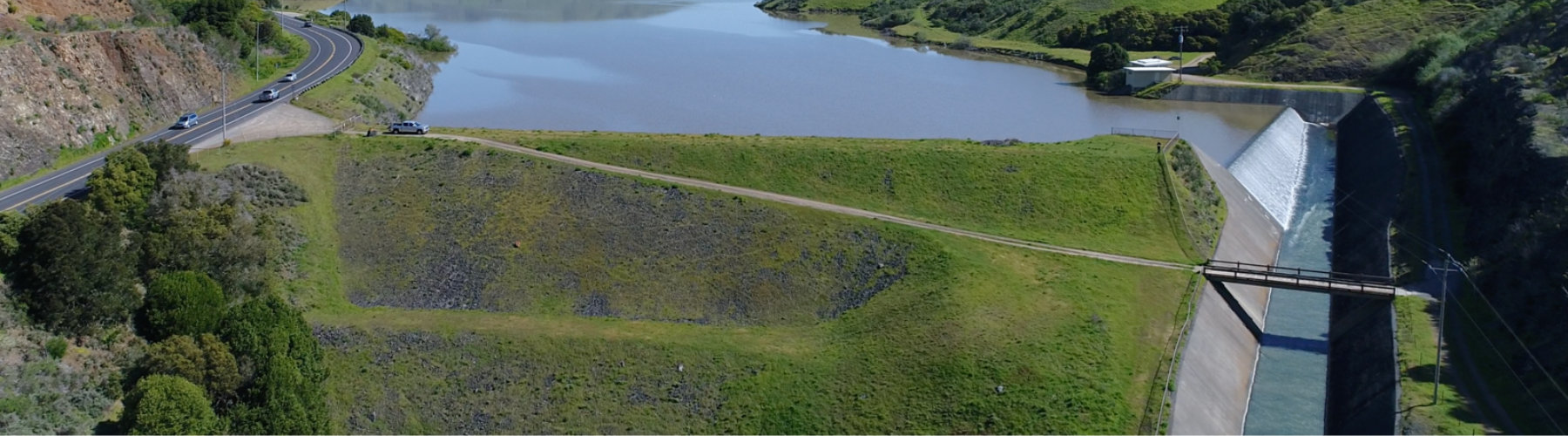 Aerial image shows a dam and spillway connected to a reservoir.