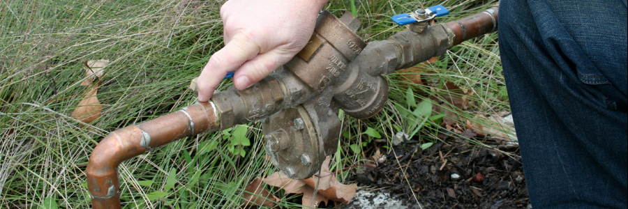 A hand on a backflow device
