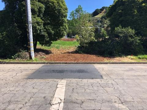 A street with patched pavement