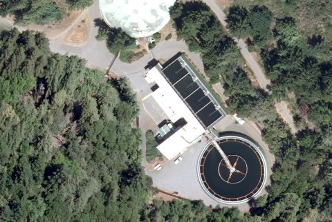 Aerial view of a water treatment plant surrounded by trees