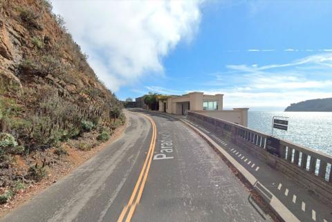 A curved road along a hillside and bay