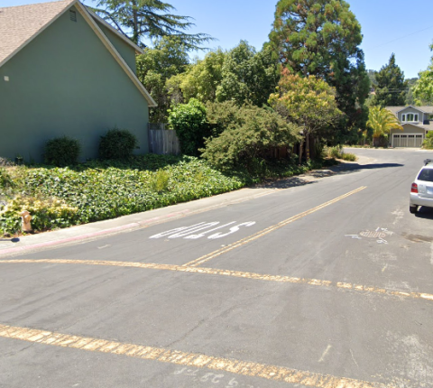 A crosswalk across a street alongside a house