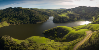 A reservoir set among rolling green hills.