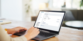 Hands rest on a laptop keyboard. The screen displays Marin Water's online billing portal.