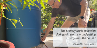A person turns a hose nozzle connected to a blue rain barrel. At right, the following words appear in a white box: “The primary use is collection during rain storms – and getting it away from the house.”  - Michael P., Lucas Valley