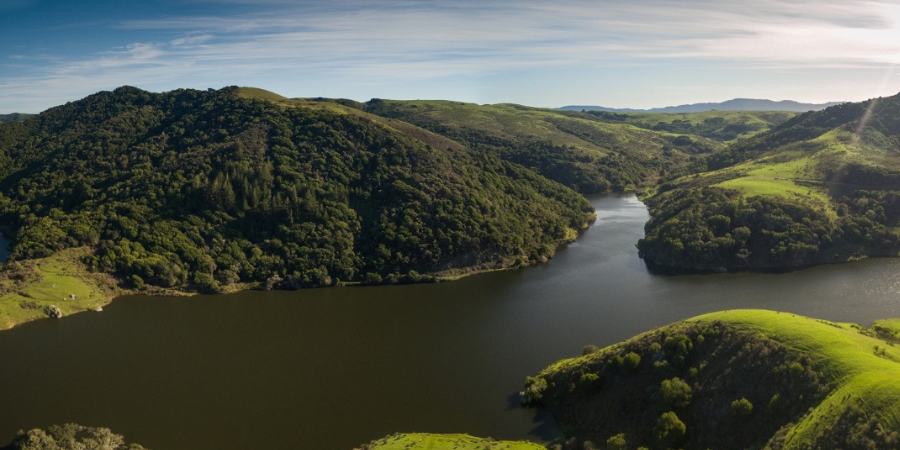 A reservoir set among rolling green hills.